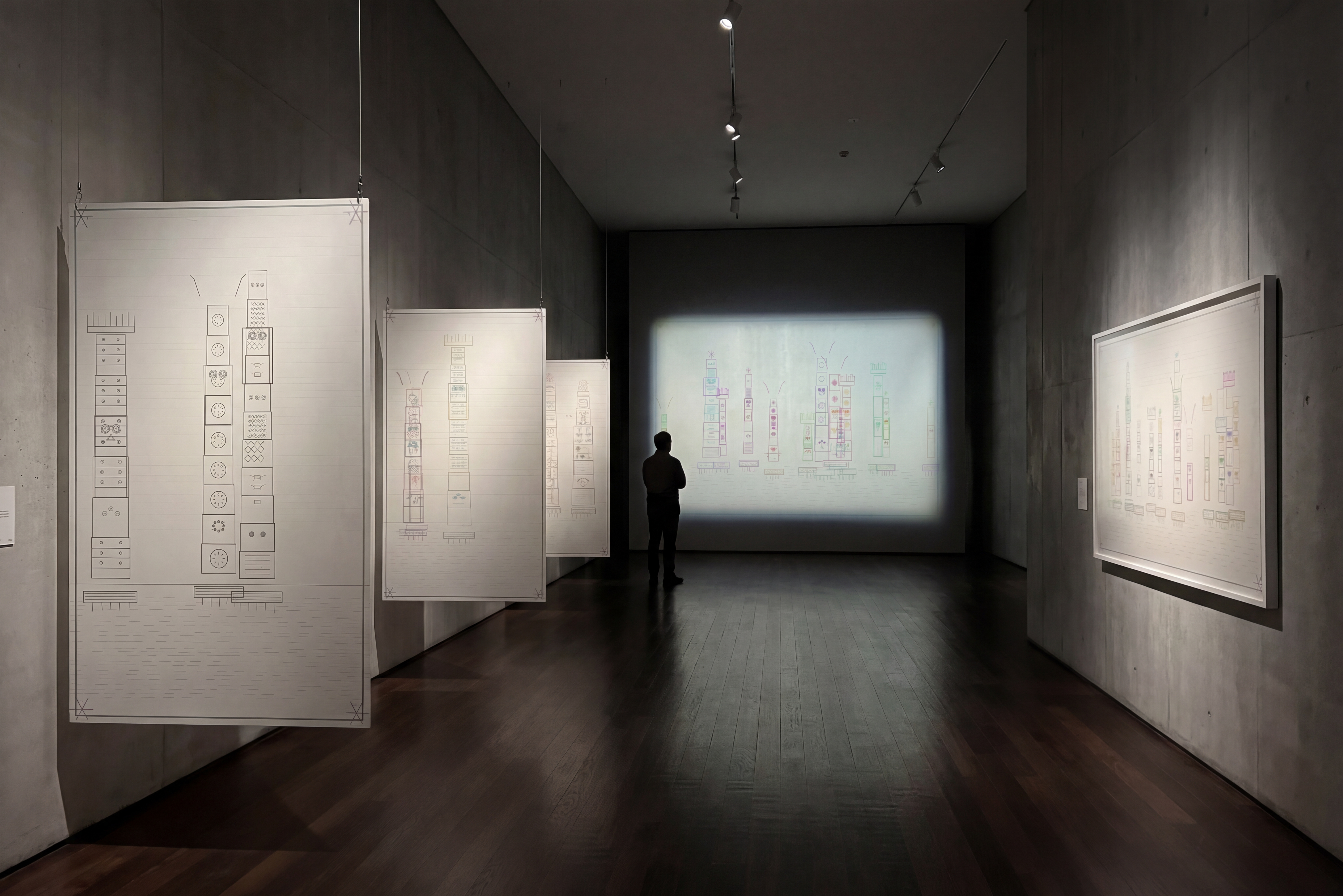 Gallery installation study — five DATASPHERE works in a museum corridor with suspended translucent architectural paper panels and a wall projection